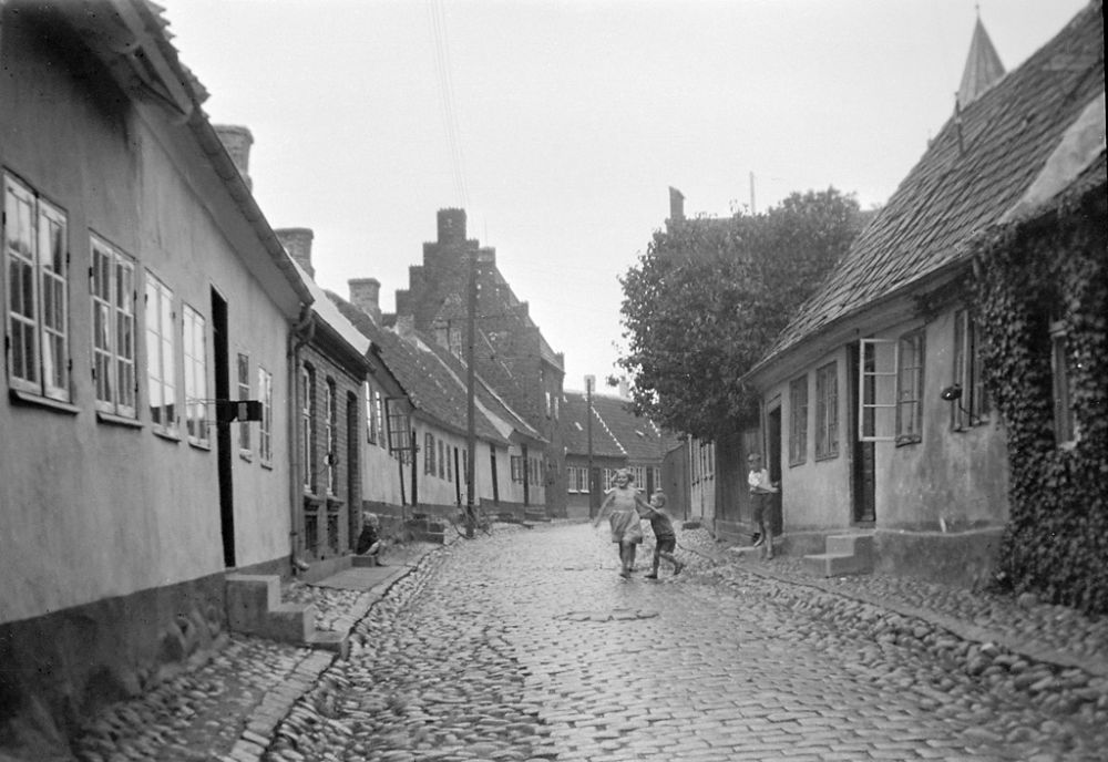 Children in Præstegade street (Priest street) in Kalundborg. In the background to the left is a medieval house with stepped gable roof. 1933