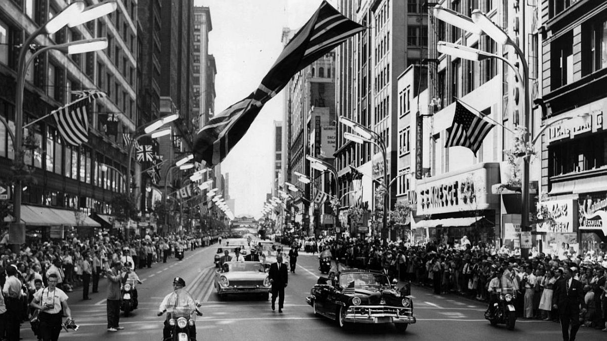 Chicago Tribune historical photo A limousine carrying Queen Elizabeth II passes beneath a huge British flag hanging above State Street while en route to the Drake Hotel in Chicago on July 6, 1959.