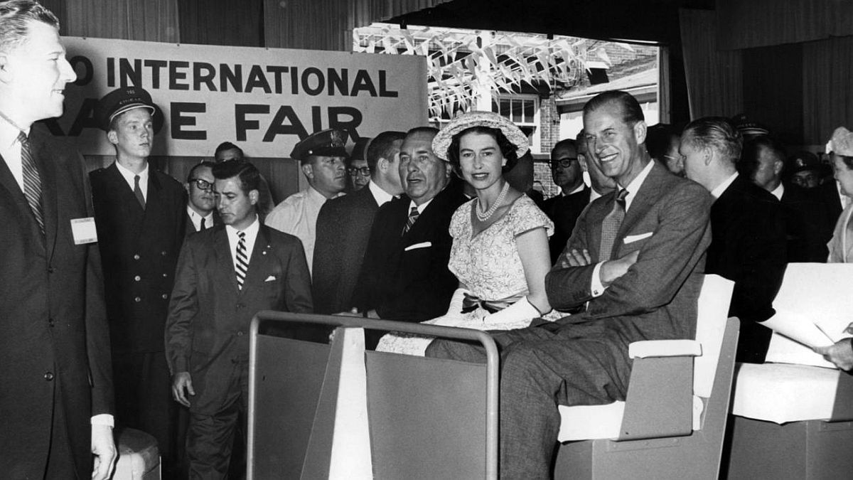 Chicago Tribune historical photo Queen Elizabeth II sits between Mayor Richard J. Daley, left, and Prince Philip as they ride in a cart at Navy Pier while touring the Chicago International Trade Fair on July 6, 1959.
