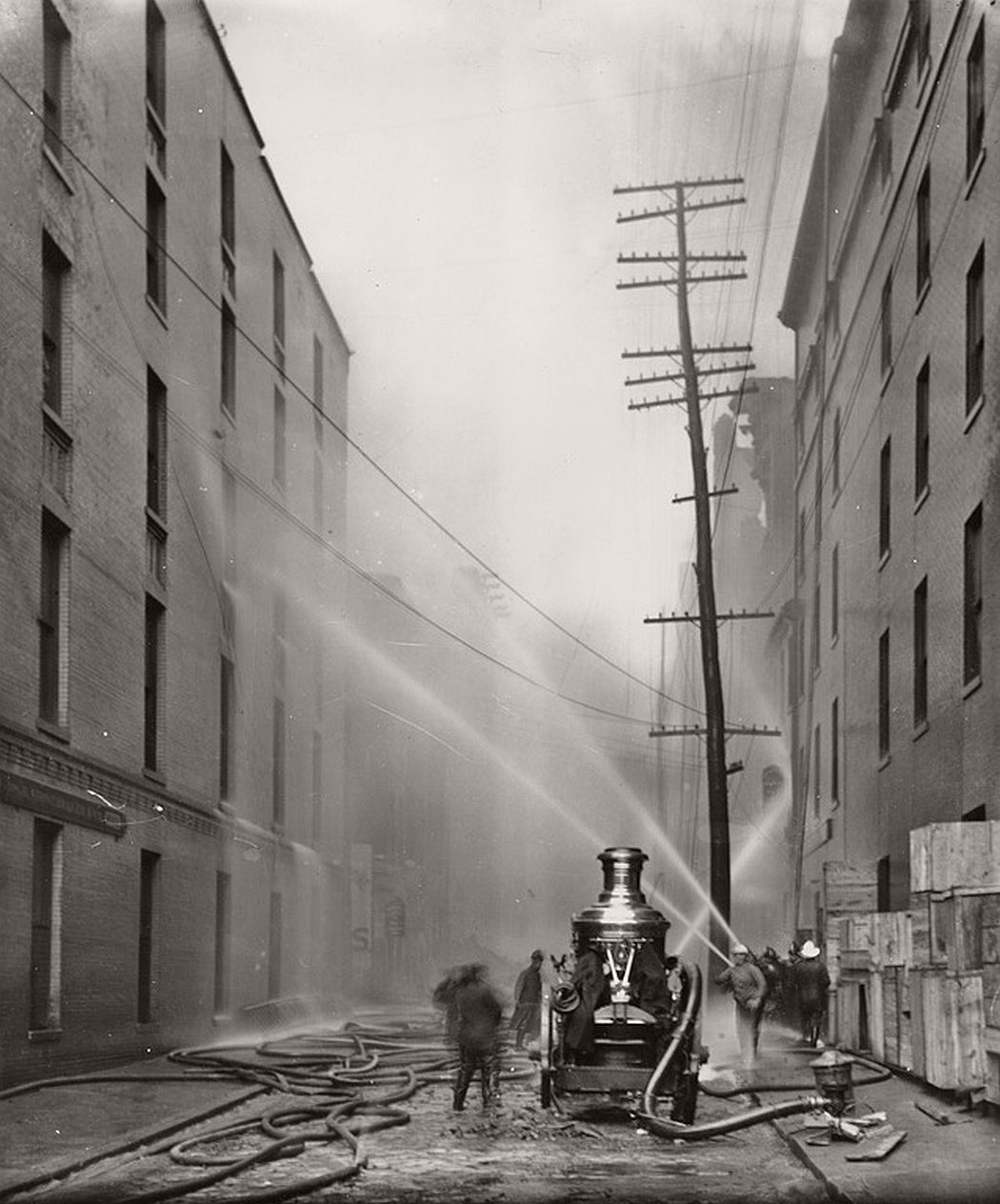 Firefighters spraying water on buildings along German St. during 1904 fire