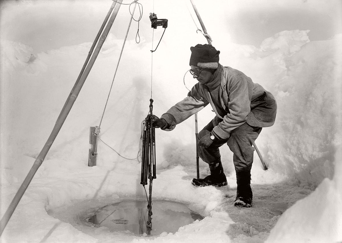 Biologist Edward Nelson tends to a scientific experiment in an ice hole on December 24, 1911.  Terra Nova biologists were fascinated by the bevy of unusual creatures around them, from leopard seals—which they called sea leopards—to killer whales to Adélie penguins.