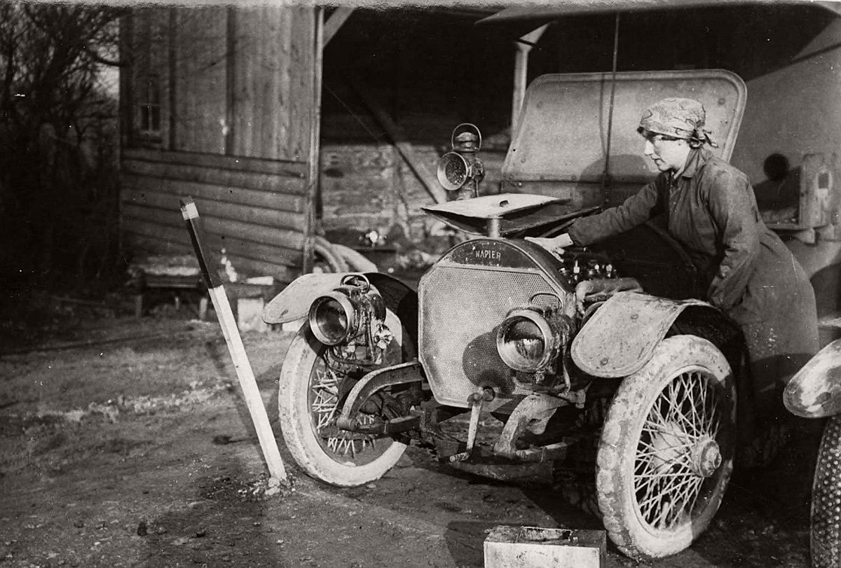   A member of the British First Aid Nursing Yeomanry oiling her car near the Western Front. # National Library of Scotland