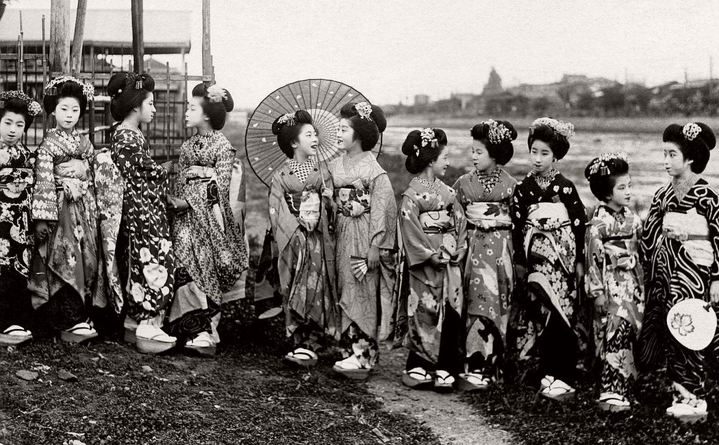 A group of Maiko girls standing on the riverbank, ca. late 1910s