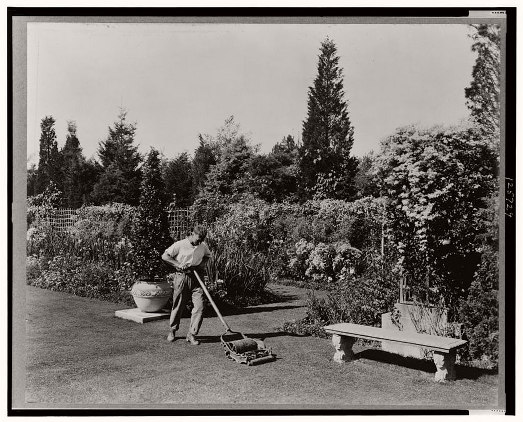 Gardener pushing lawn mower, posed to illustrate Rudyard Kipling's poem The Glory of the Garden, 1917.