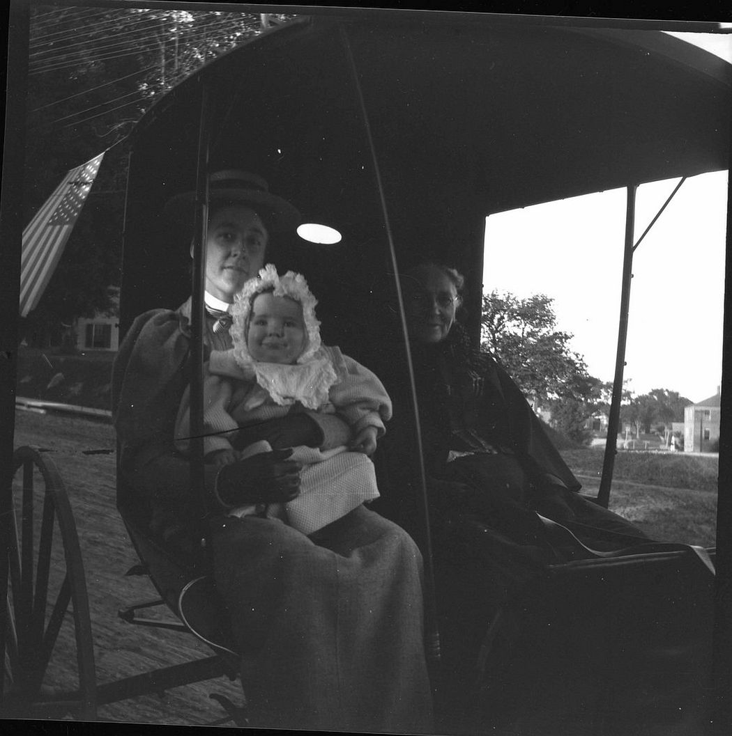 Nellie and baby Theodore in carriage with elderly lady.