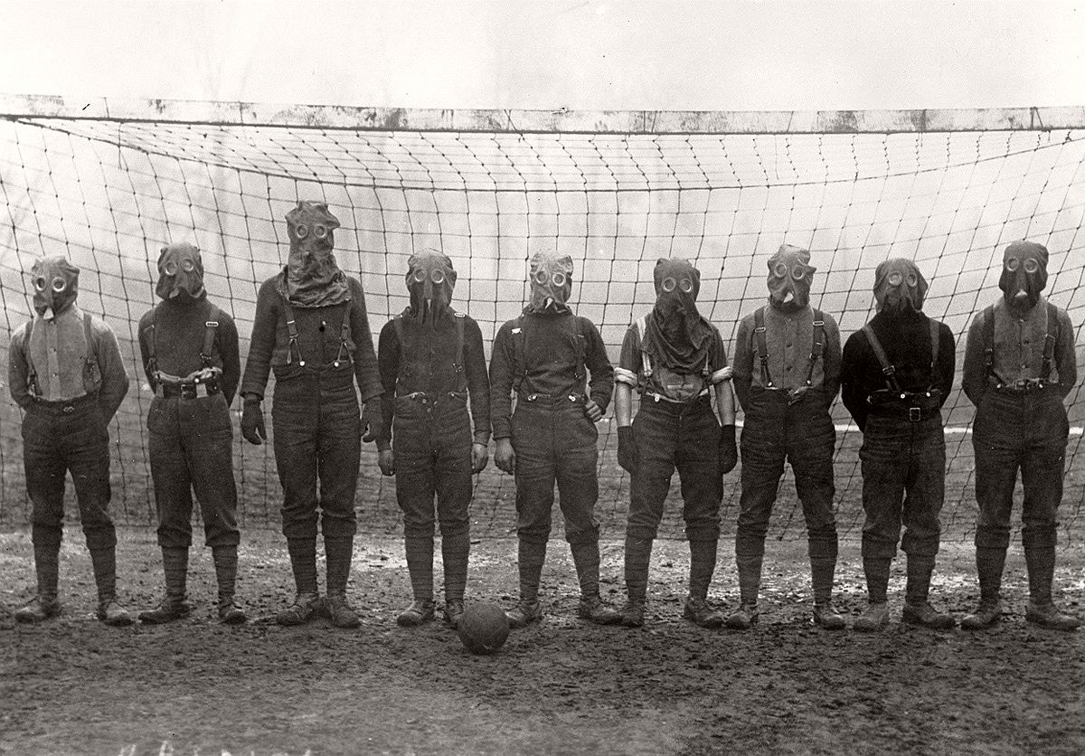   British soldiers play football while wearing gas masks, France, 1916. # Bibliotheque nationale de France