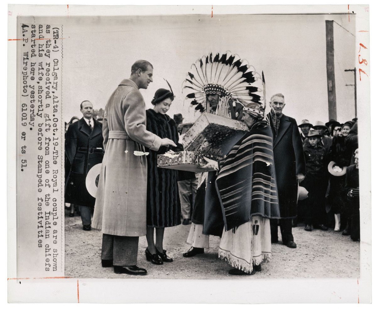 Unknown photographer for The Associated Press, Untitled [Princess Elizabeth and the Duke of Edinburgh receiving a gift from Chief Little Dog (Kainai Nation) and his wife Antoinette Heavy Shield (Siksika Nation) before the Stampede, Calgary, Alberta], October 19, 1951. Photo courtesy of the Rudolph P. Bratty Family Collection, Ryerson Image Centre.