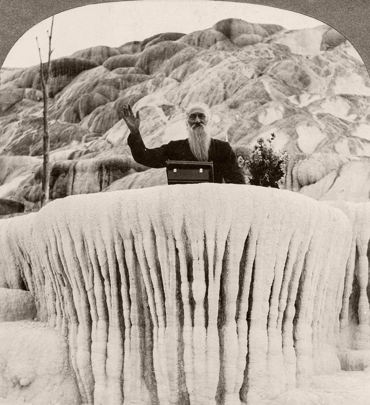 A man stands behind the "Pulpit Terrace" formation at the Mammoth Hot Springs in Yellowstone, 1904. (Library of Congress)