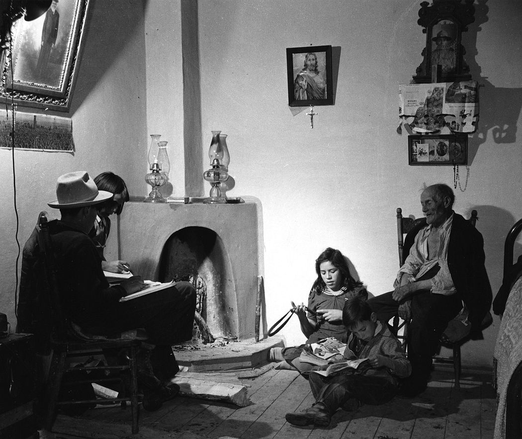 A family in front of kiva fireplace, Trampas, New Mexico, 1943