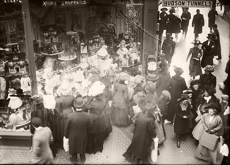 Shoppers gather around a window, 1900.