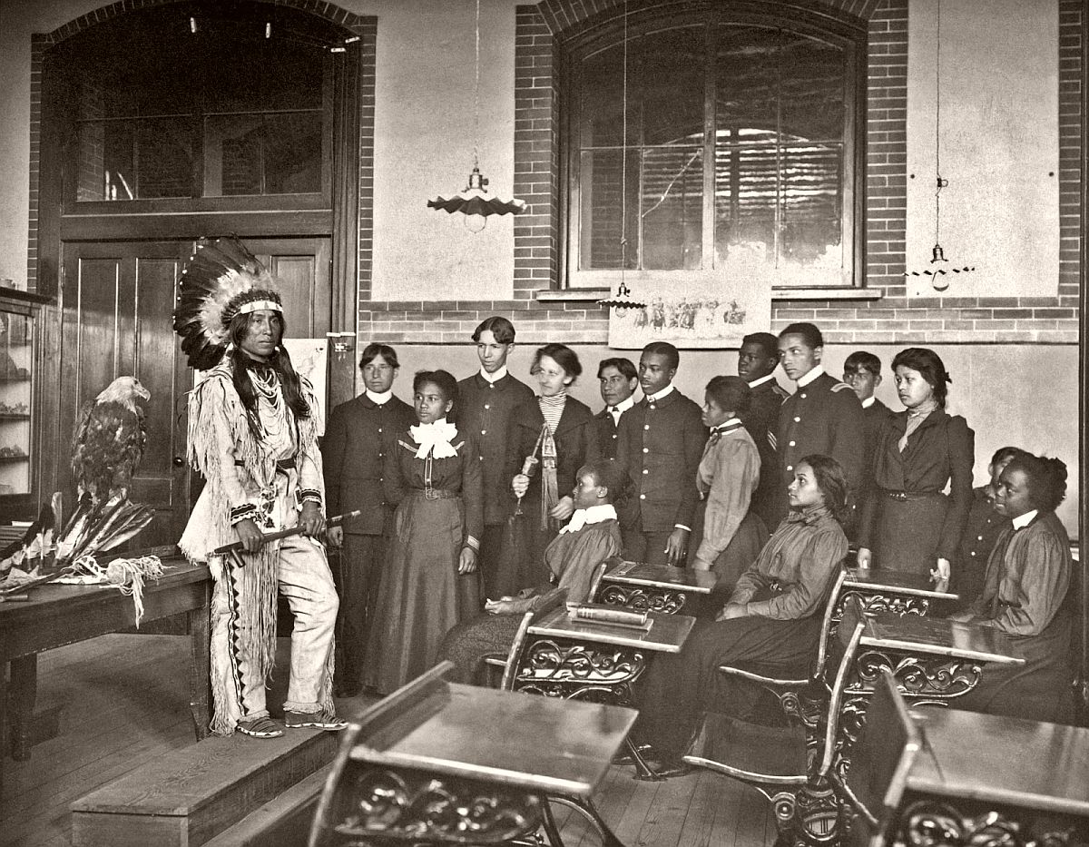 Louis Firetail (Sioux, Crow Creek), wearing tribal clothing, giving a presentation in an American history class, Hampton Institute, Hampton, Virginia, 1899-1900