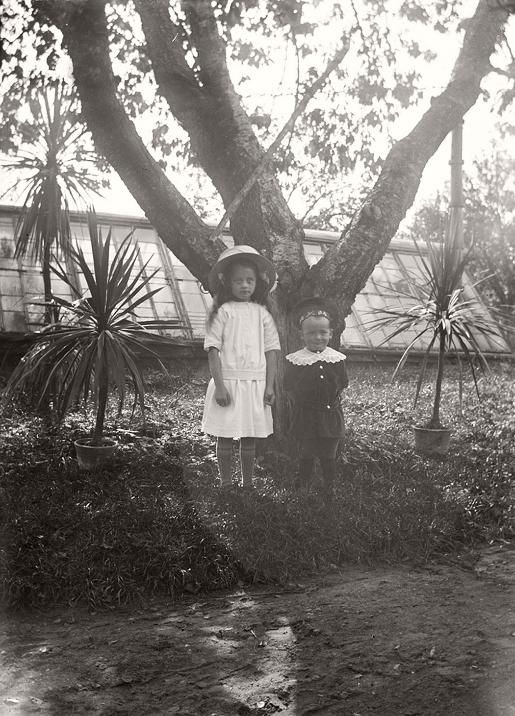 Two children outside the greenhouse.