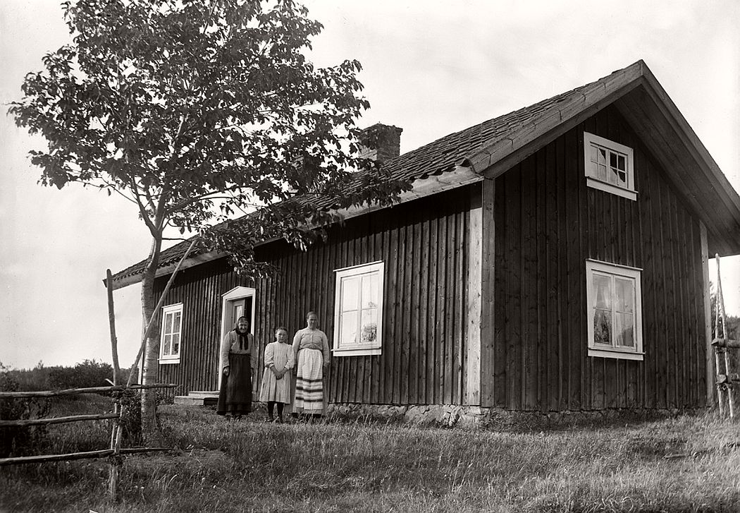 Two women and a girl in front their cottage in Sjöstugan, 1912.