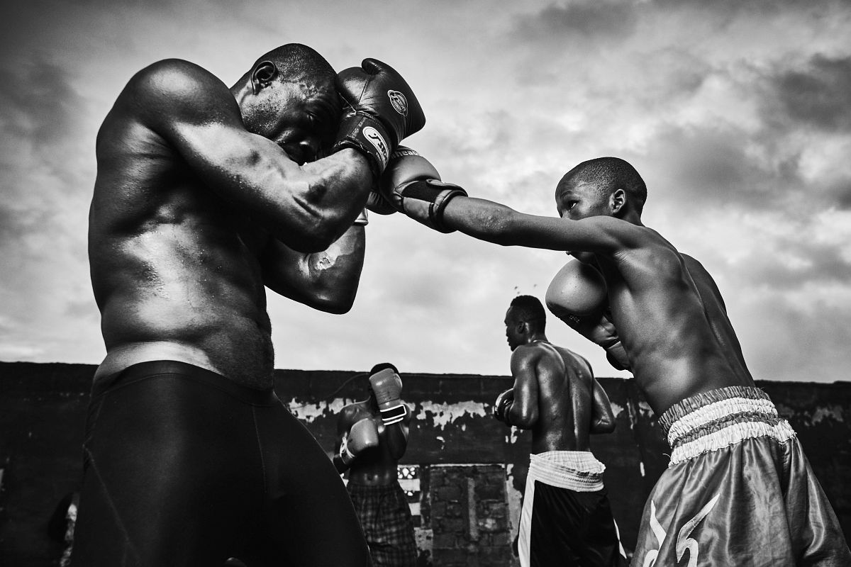 From left - Boxers Atu Ricketts and Emmanuel Fofo Mawuli sparring during training at "Charles Quartey Boxing Foundation", in Accra, Ghana, on September 29th, 2017. Young up and coming boxer Emmanuel Fofo Mawuli lands a punch on the defense of Atu Rickets. "Fofo" trains along with the adults and current champions at Charles Quartey Boxing Foundation as he grows up in boxing.