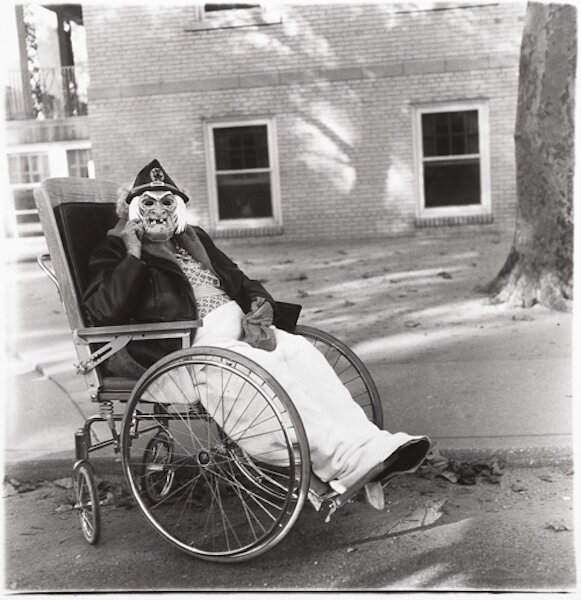 DIANE ARBUS  Masked Woman in a Wheelchair, PA, 1970