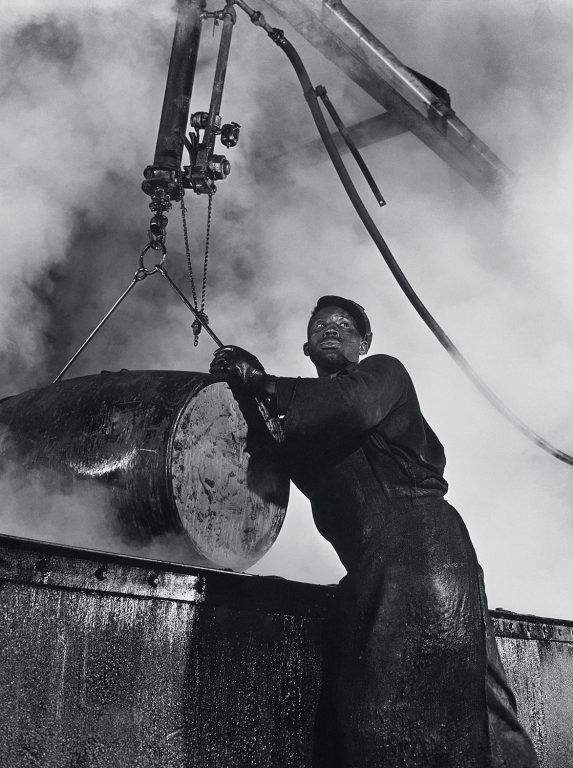 Gordon Parks, The cooper’s room where the large drums and containers are reconditioned. Here a workman lifts a drum from a boiling lye solution which has cleaned from it grease and dust particles, 1944, Prints and Photographs Division, Library of Congress, Washington DC, Courtesy of the Gordon Parks Foundation