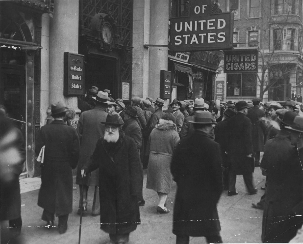 Crowd gathers in front of the doors of the Bank of the United States on Freeman Street, New York. April, 1931. 