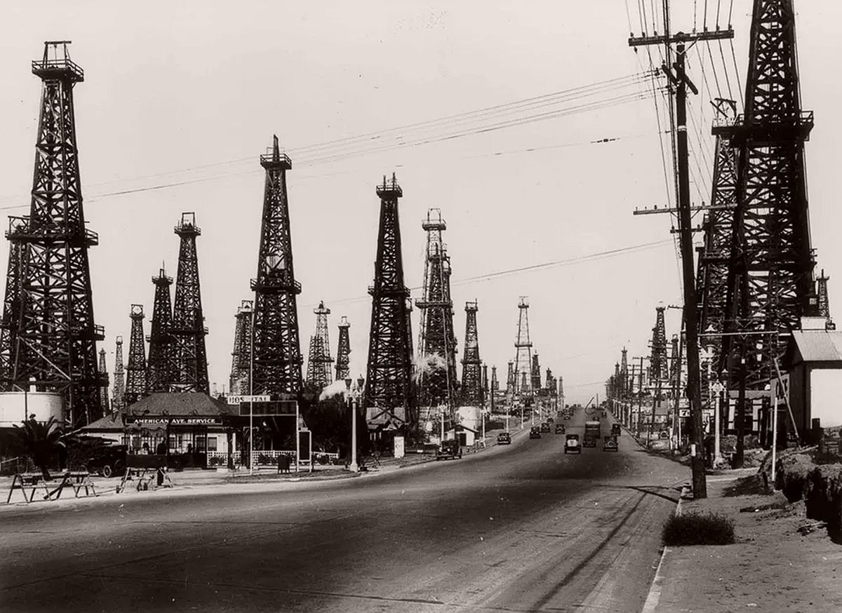 Oil derricks line a road outside Los Angeles. 1930.