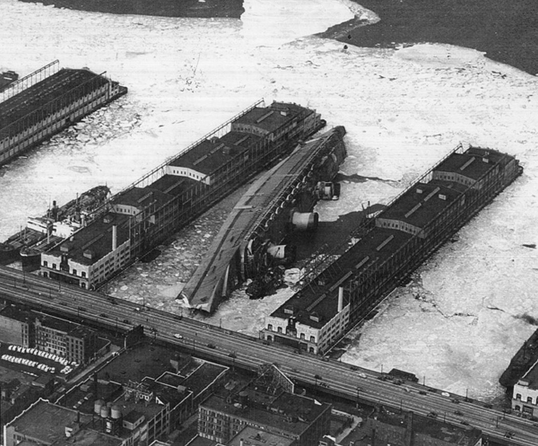 Normandie, renamed USS Lafayette, lies capsized in the frozen mud of her New York pier in the winter of 1942